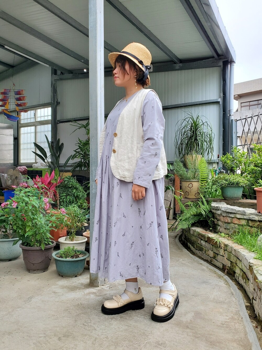 ブルー系のワンピース、ベージュ系のベスト、ピンク系のバレエシューズを着用したレディースの春コーディネートの3枚目の写真