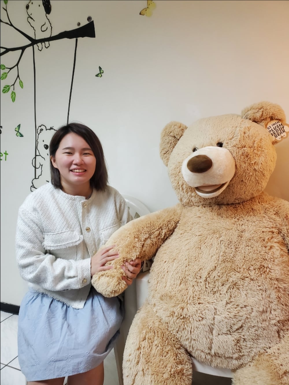 ホワイト系のノーカラージャケット、ブルー系のワンピース/ドレス、ホワイト系のパンプスを着用したレディースの冬コーディネートの2枚目の写真