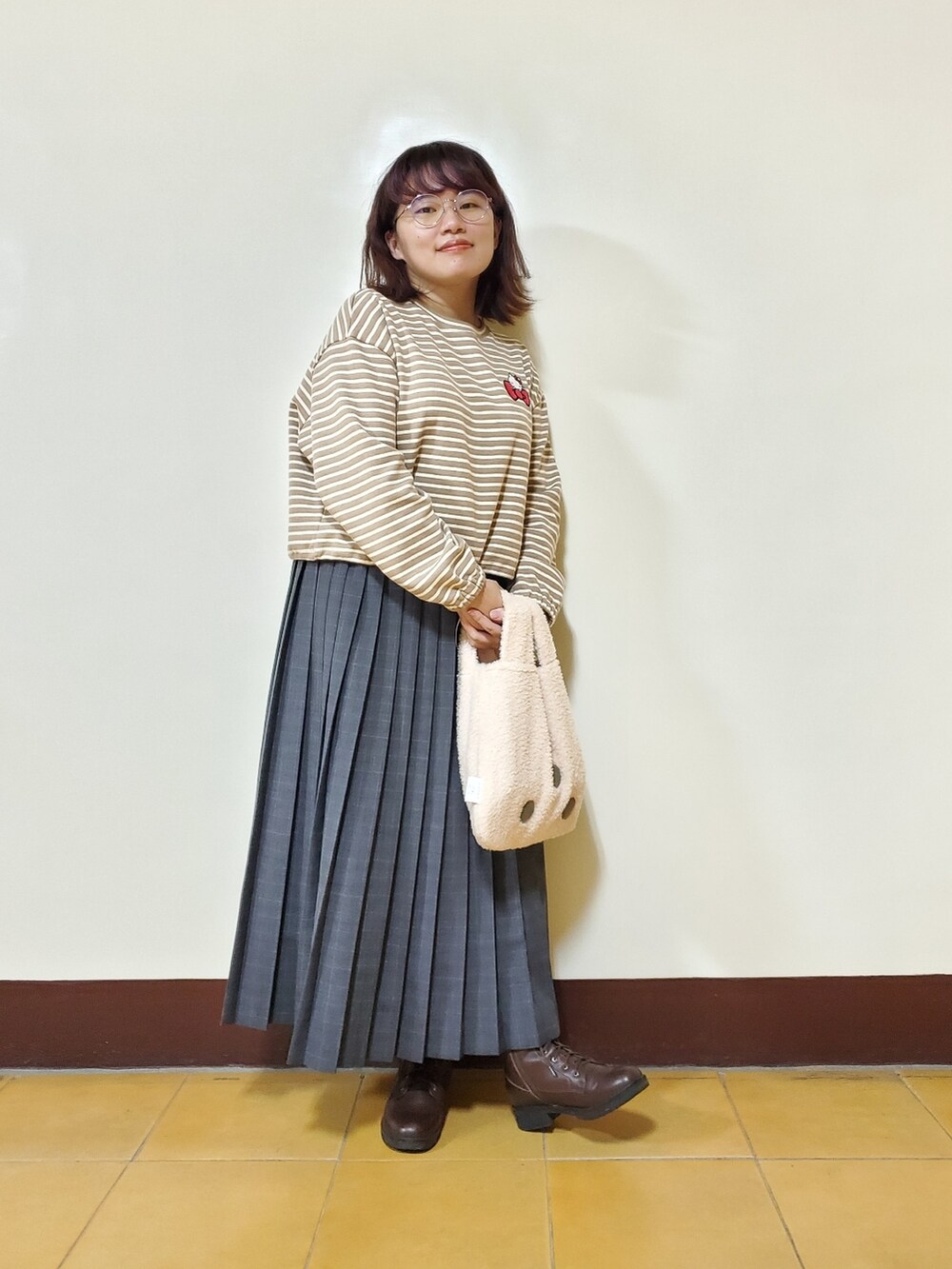 オレンジ系のその他アウター、ホワイト系のベスト、ベージュ系のTシャツ/カットソーを着用したレディースの冬コーディネートの5枚目の写真
