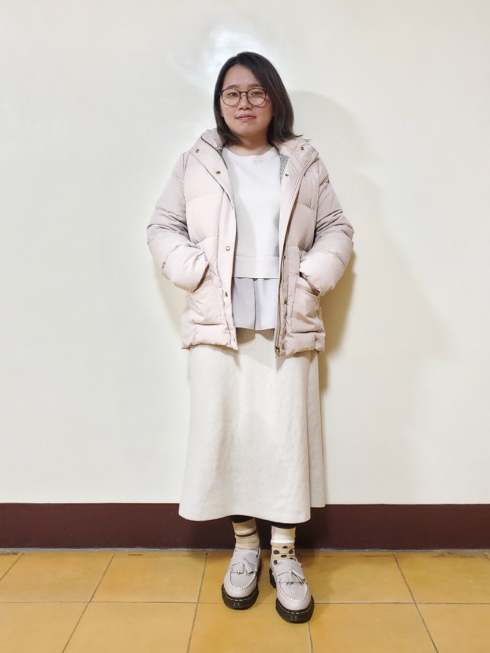 ベージュ系のダウンジャケット/コート、ベージュ系のニット/セーター、ベージュ系のスカートを着用したレディースの冬コーディネートの5枚目の写真