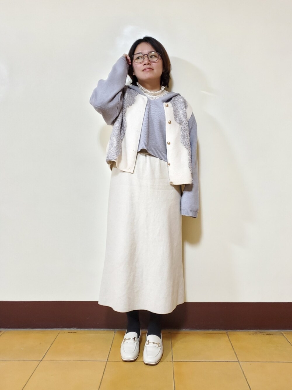 ブルー系のニット/セーター、ホワイト系のトップス、ベージュ系のスカートを着用したレディースの春コーディネートの3枚目の写真