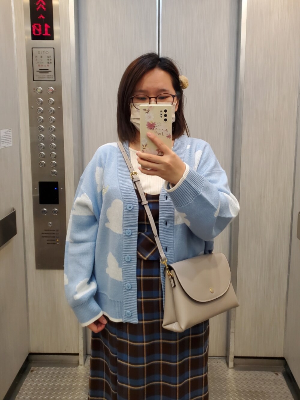 ブルー系のカーディガン/ボレロ、ブラウン系のベスト、ブラウン系のスカートを着用したレディースの冬コーディネートの2枚目の写真