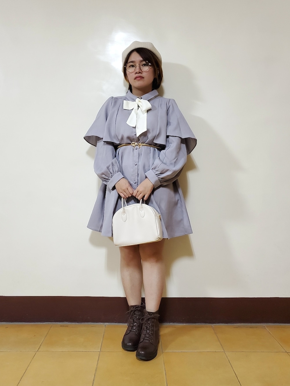 パープル系のワンピース、ブラウン系のブーツ、ホワイト系のトートバッグを着用したレディースの春コーディネートの4枚目の写真