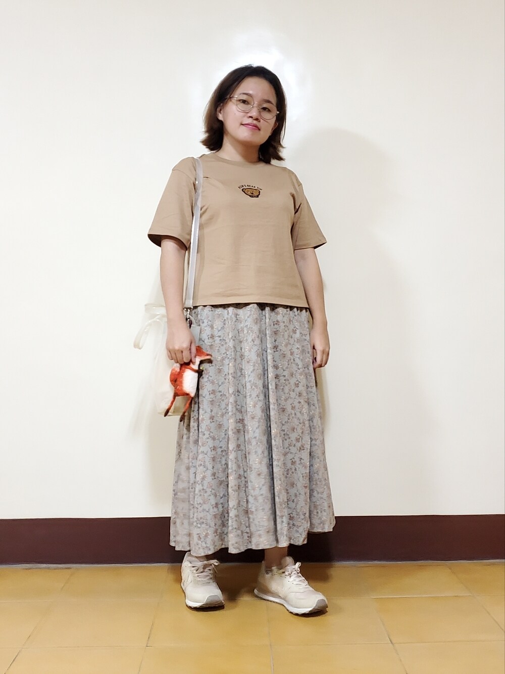 ブラウン系のTシャツ/カットソー、グリーン系のスカート、ベージュ系のシューズを着用したレディースの秋コーディネートの2枚目の写真