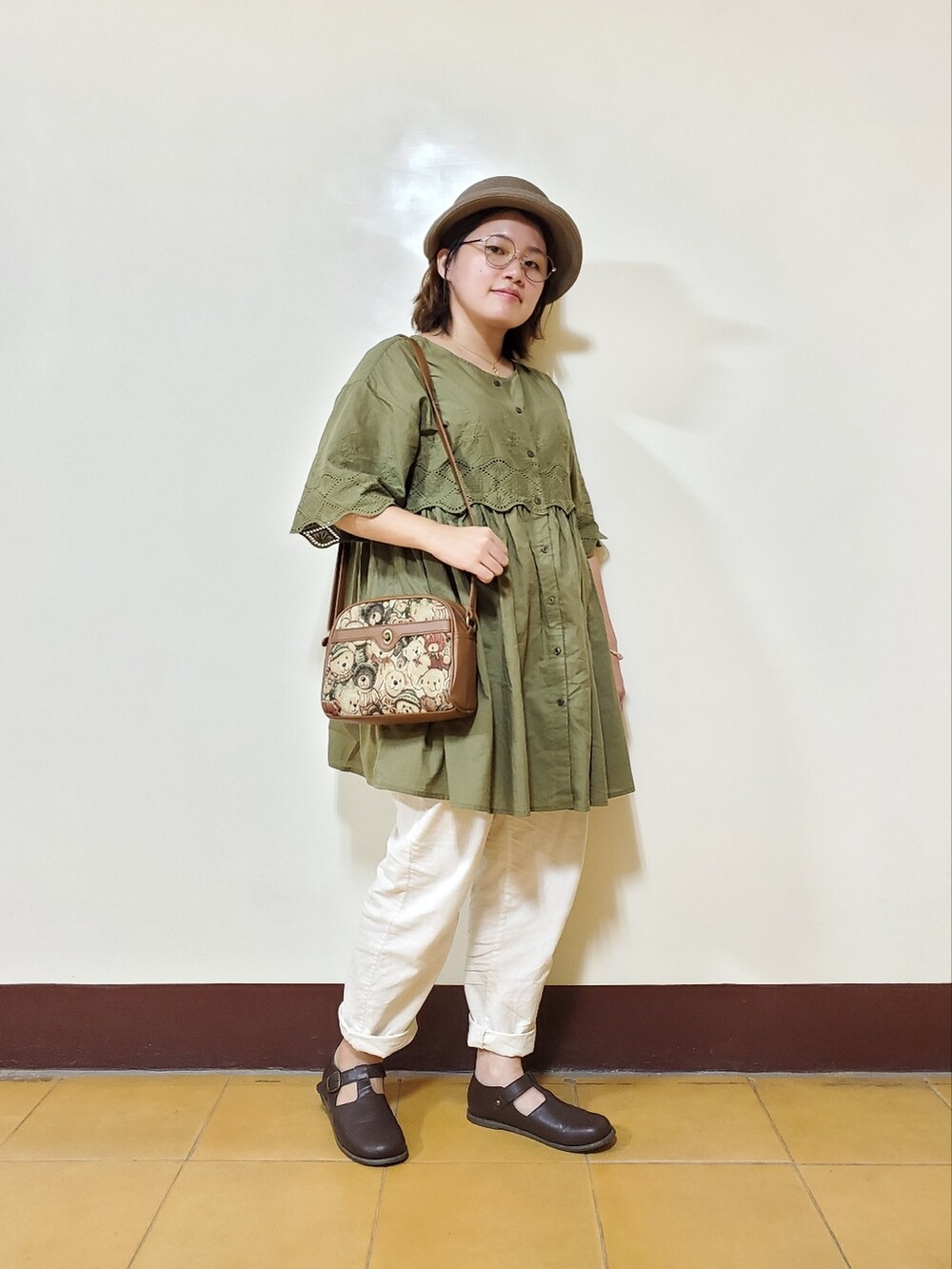 グリーン系のチュニック、ホワイト系のその他パンツ、ブラウン系のドレスシューズを着用したレディースの秋コーディネートの2枚目の写真