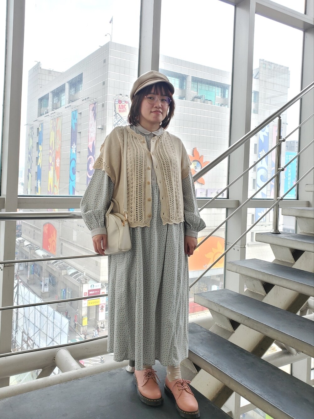 グリーン系のワンピース、ホワイト系のベスト、ピンク系のシューズを着用したレディースの夏コーディネートの2枚目の写真