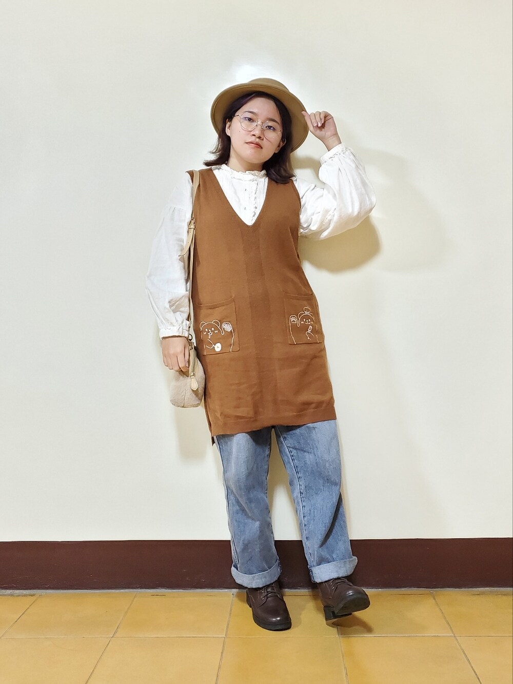 オレンジ系のその他アウター、ホワイト系のベスト、ブラウン系のワンピース/ドレスを着用したレディースの冬コーディネートの5枚目の写真