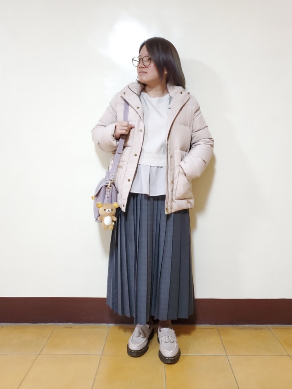 ベージュ系のニット/セーター、グレー系のスカート、グレー系のローファーを着用したレディースの冬コーディネートの2枚目の写真