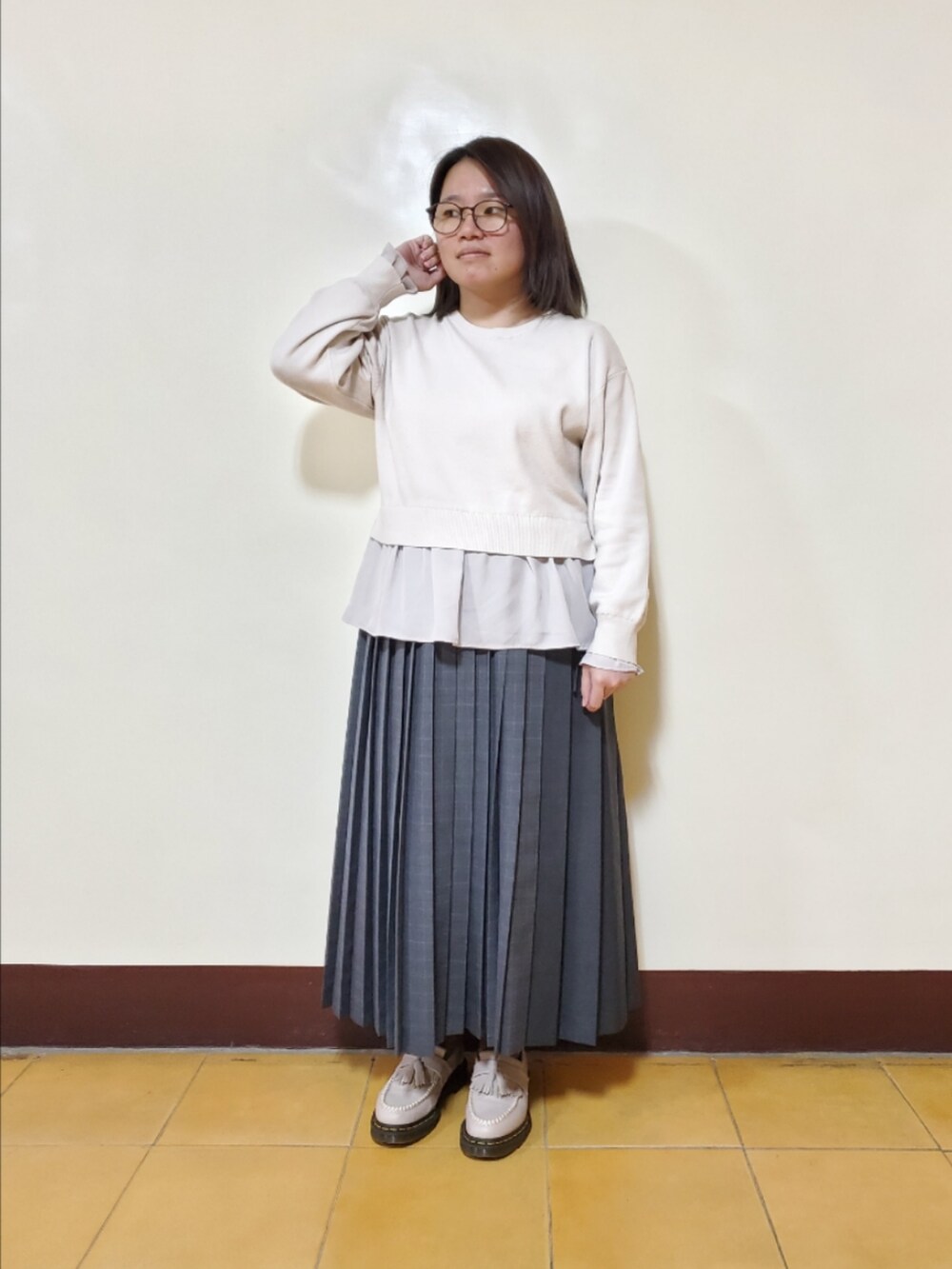 ベージュ系のニット/セーター、グレー系のスカート、グレー系のローファーを着用したレディースの冬コーディネートの3枚目の写真