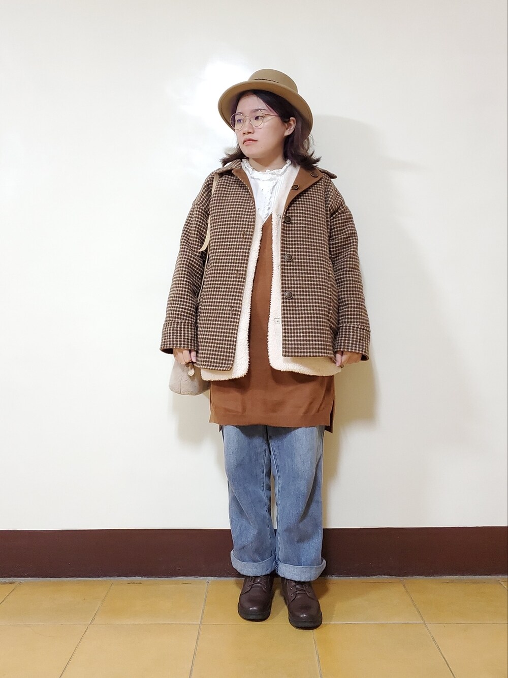 オレンジ系のその他アウター、ホワイト系のベスト、ブラウン系のワンピース/ドレスを着用したレディースの冬コーディネートの2枚目の写真