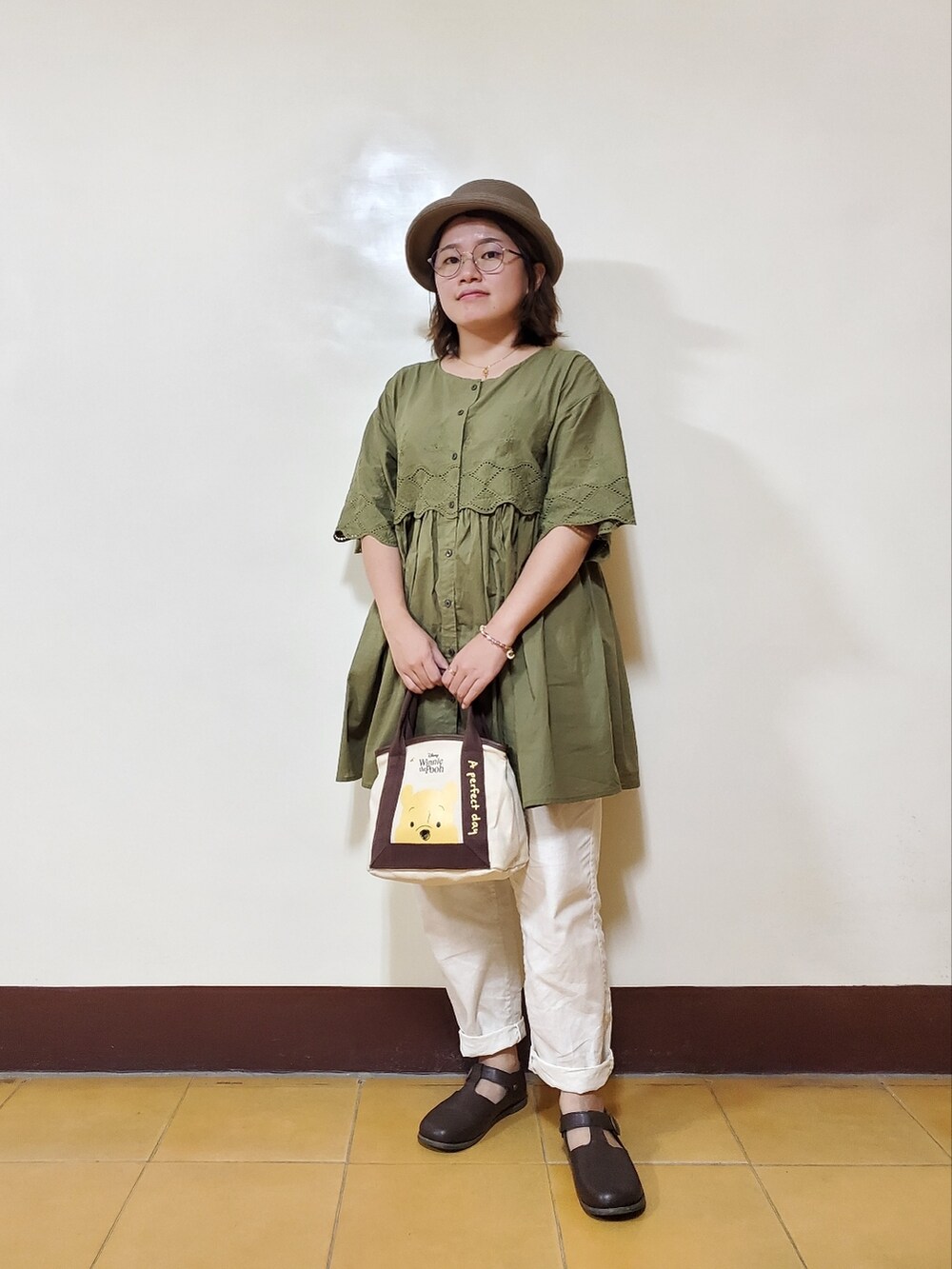 グリーン系のチュニック、ホワイト系のその他パンツ、ブラウン系のドレスシューズを着用したレディースの秋コーディネートの3枚目の写真