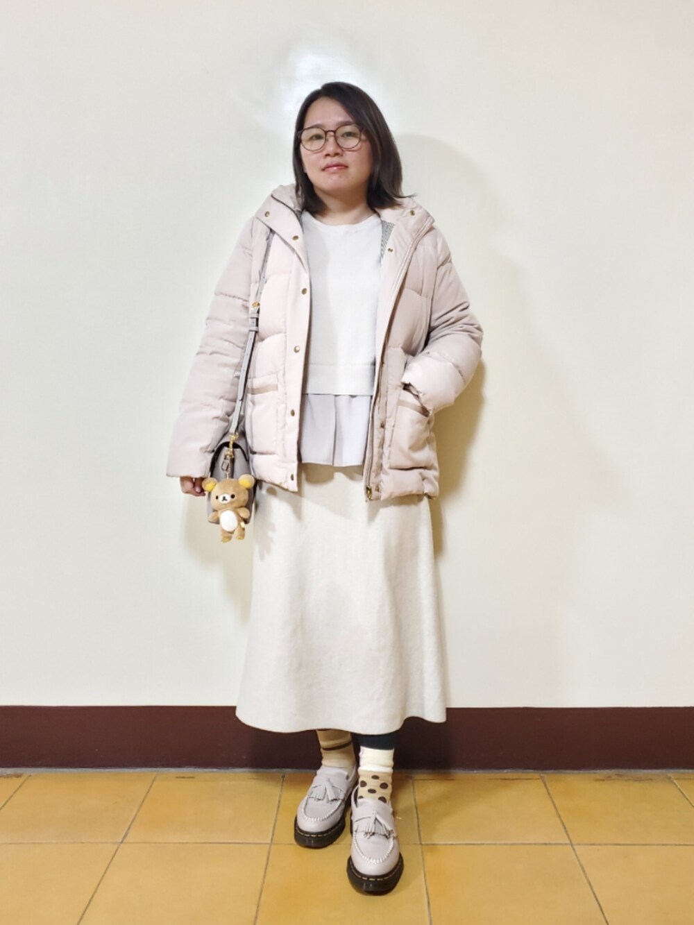 ベージュ系のダウンジャケット/コート、ベージュ系のニット/セーター、ベージュ系のスカートを着用したレディースの冬コーディネートの4枚目の写真