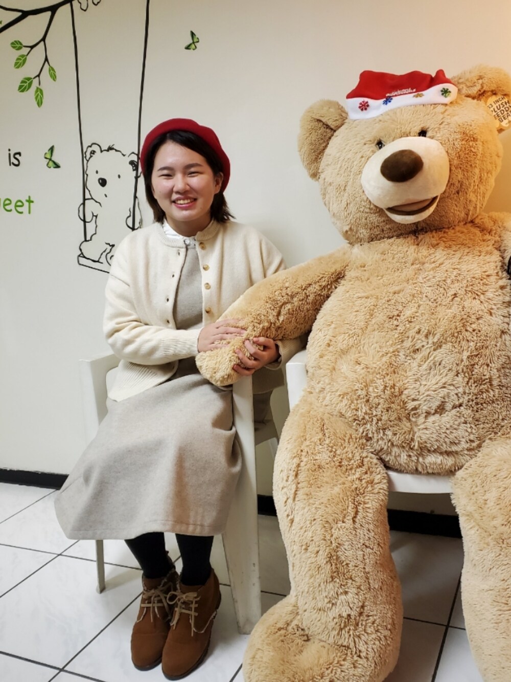 ホワイト系のカーディガン/ボレロ、ベージュ系のジャンパースカート、ホワイト系のシャツ/ブラウスを着用したレディースの冬コーディネートの2枚目の写真