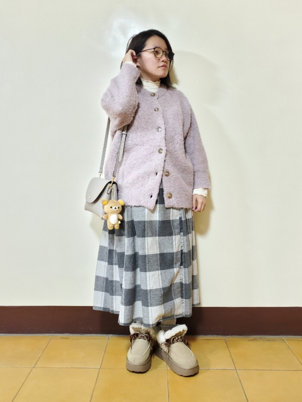 パープル系のカーディガン/ボレロ、ホワイト系のTシャツ/カットソー、グレー系のスカートを着用したレディースの冬コーディネートの2枚目の写真