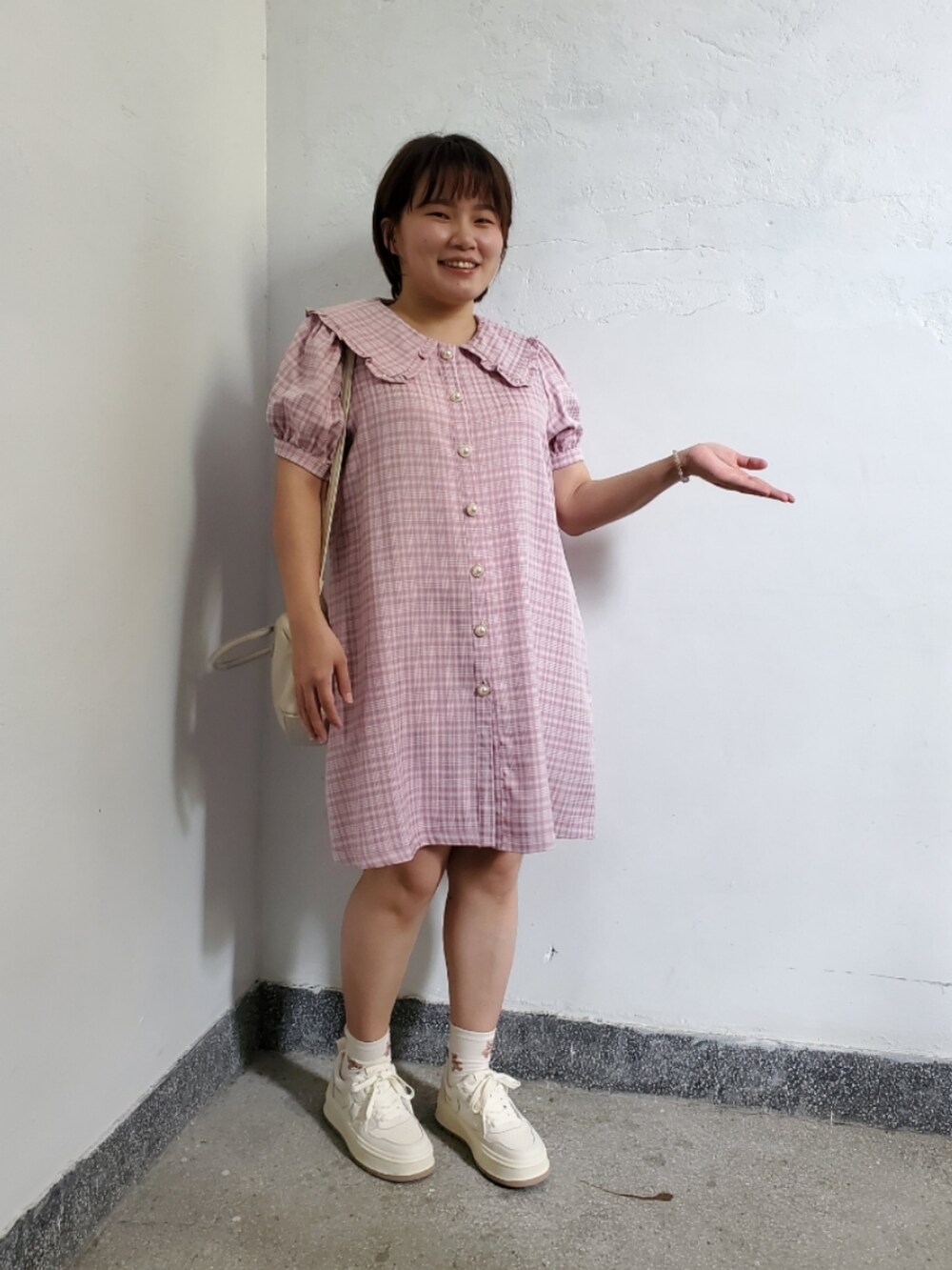 ピンク系のシャツワンピース、ホワイト系のスニーカー、ホワイト系のトートバッグを着用したレディースの秋コーディネートの2枚目の写真