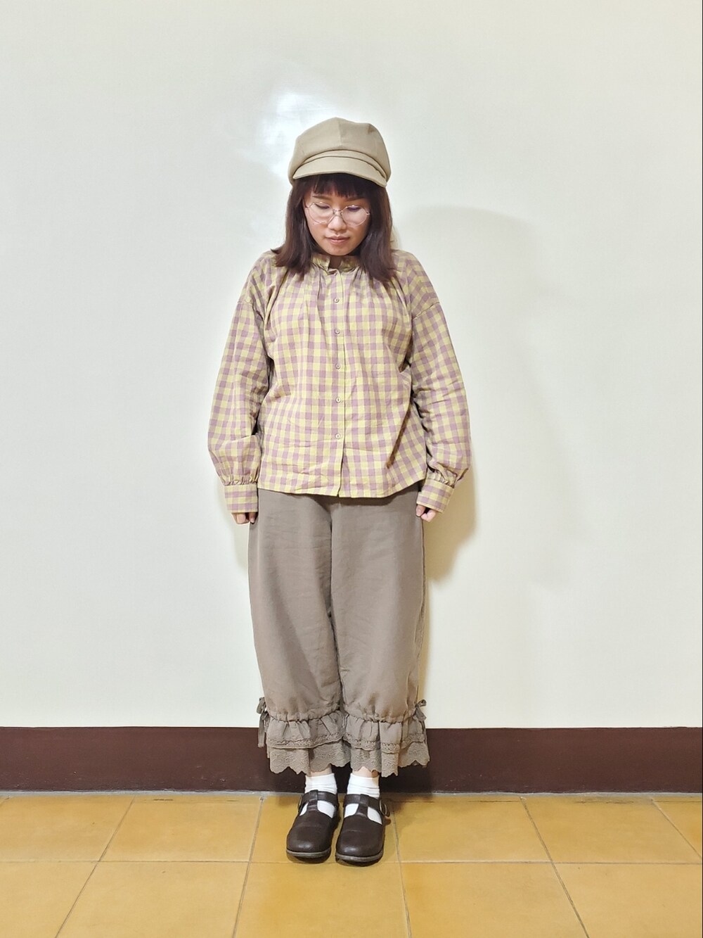 グリーン系のダウンジャケット/コート、イエロー系のシャツ/ブラウス、ブラウン系のその他パンツを着用したレディースの春コーディネートの2枚目の写真