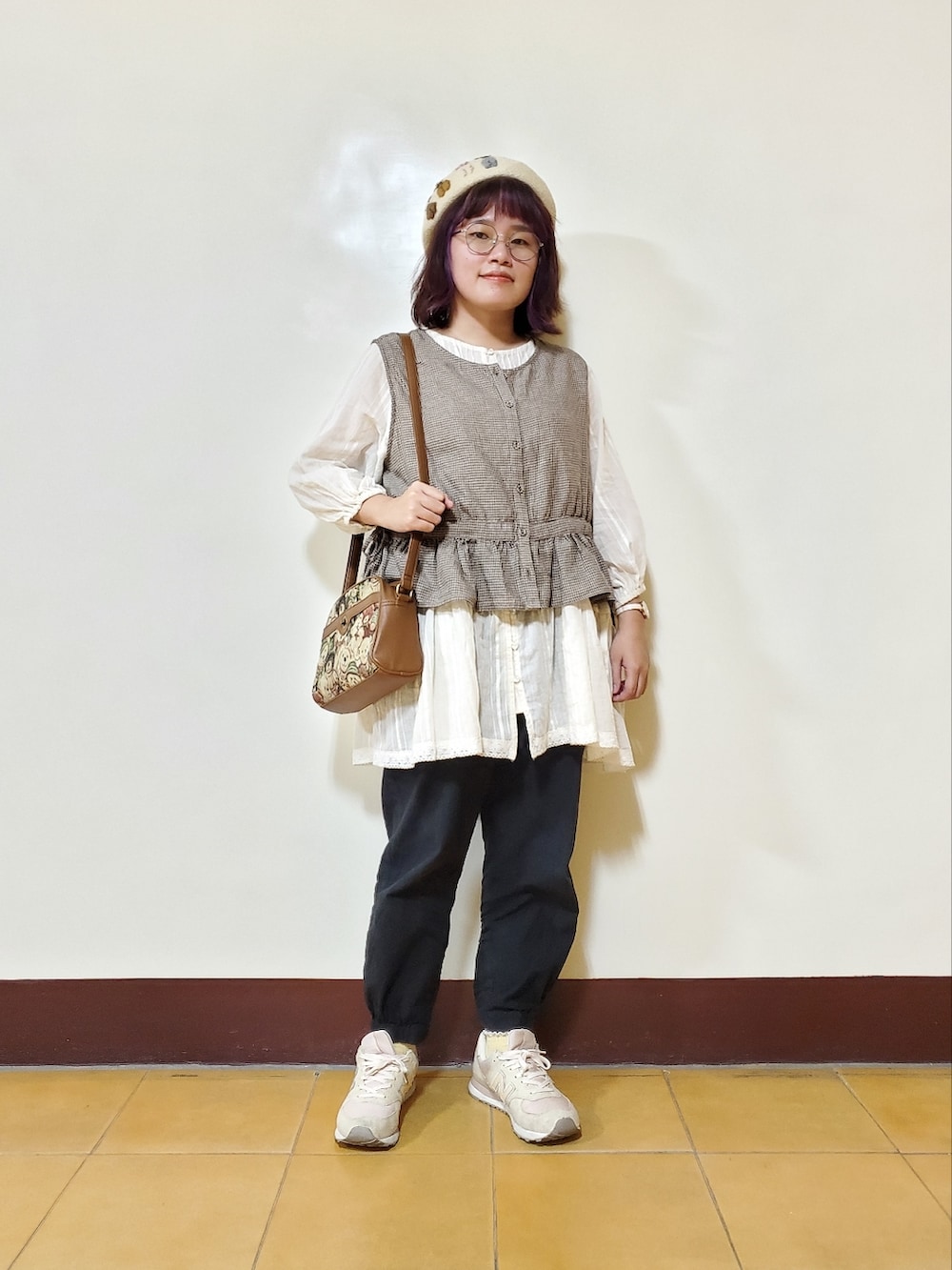 グレー系のベスト、ホワイト系のシャツ/ブラウス、ブラック系のその他パンツを着用したレディースの秋コーディネートの2枚目の写真