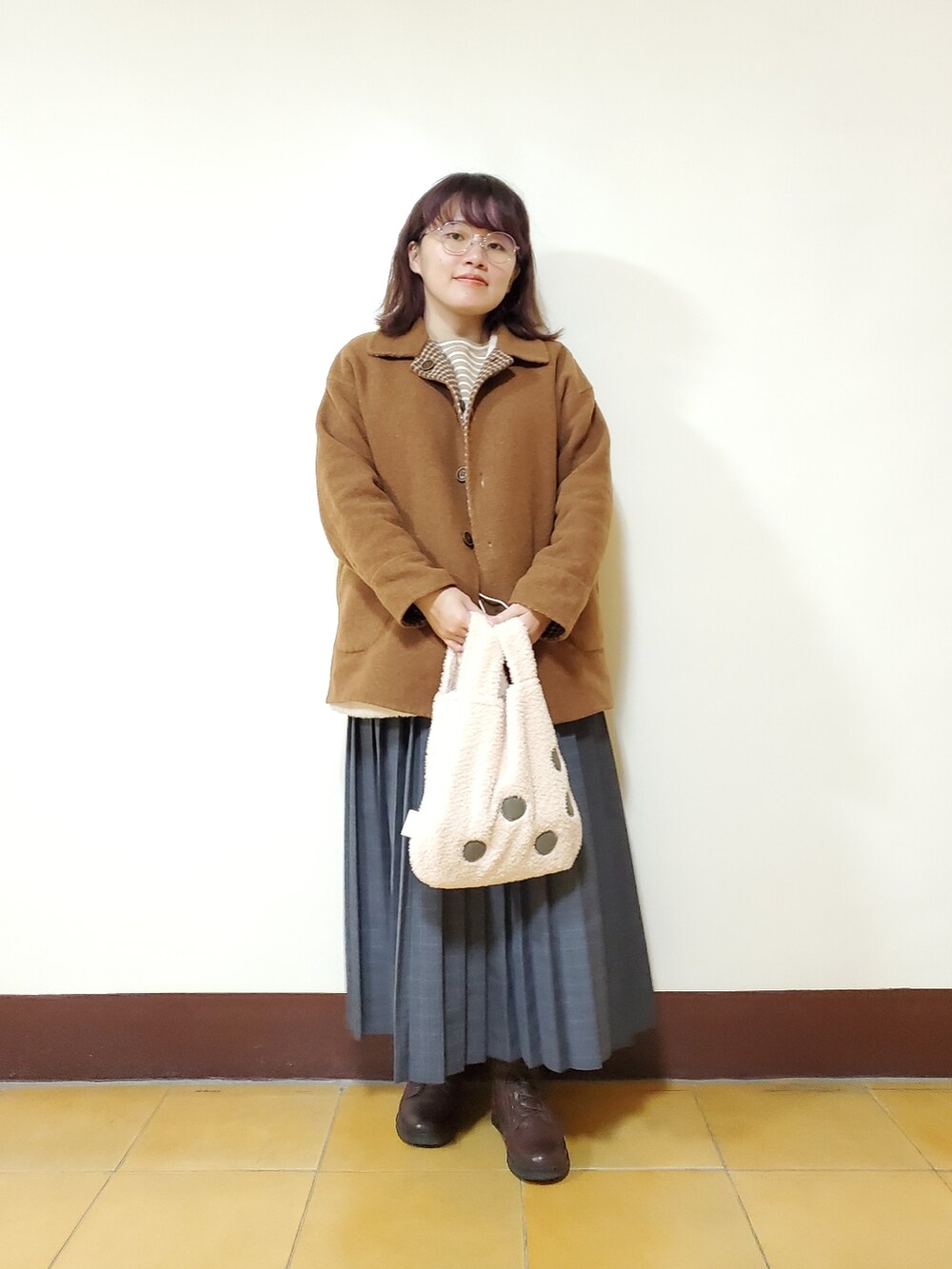 オレンジ系のその他アウター、ホワイト系のベスト、ベージュ系のTシャツ/カットソーを着用したレディースの冬コーディネートの3枚目の写真
