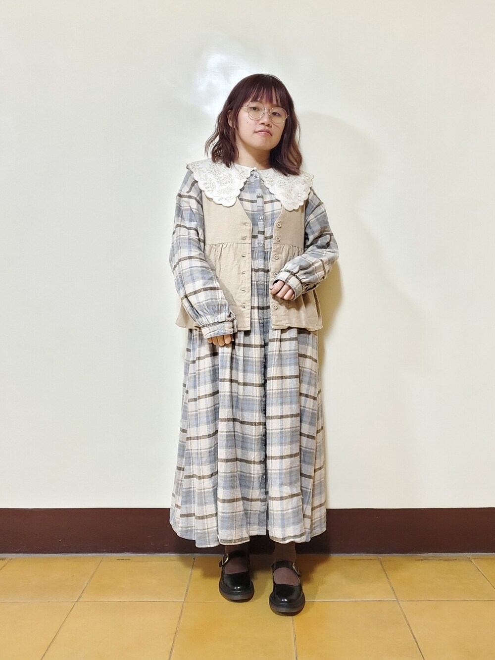 ブルー系のワンピース、ベージュ系のベスト、ブラック系のドレスシューズを着用したレディースの春コーディネートの4枚目の写真