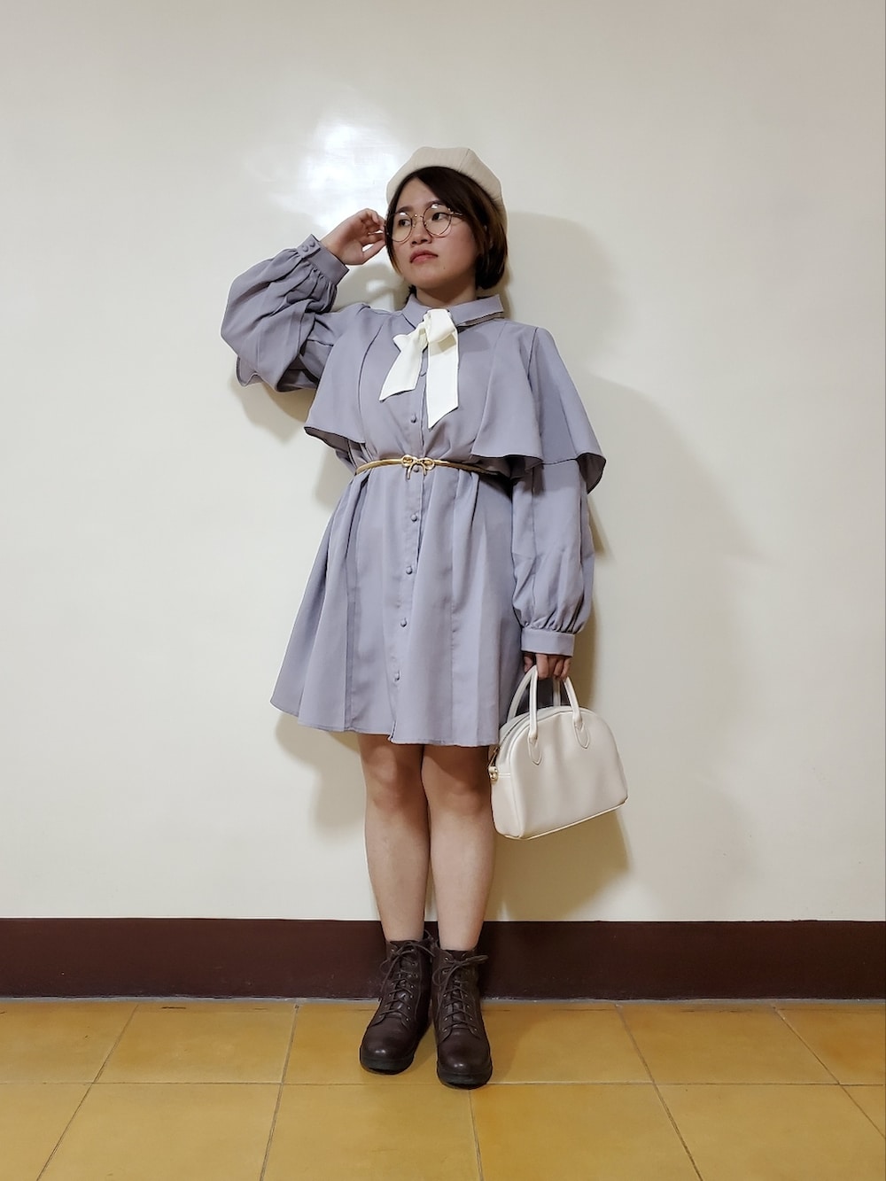パープル系のワンピース、ブラウン系のブーツ、ホワイト系のトートバッグを着用したレディースの春コーディネートの2枚目の写真
