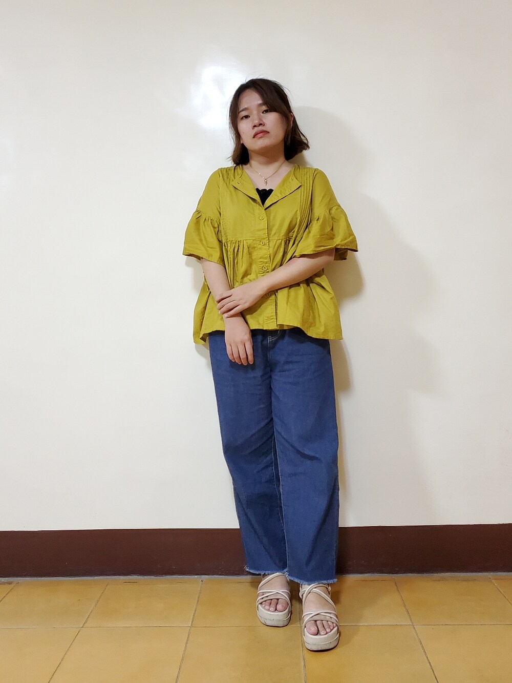 イエロー系のシャツ/ブラウス、ブラック系のキャミソール、ブルー系のデニムパンツを着用したレディースの夏コーディネートの2枚目の写真