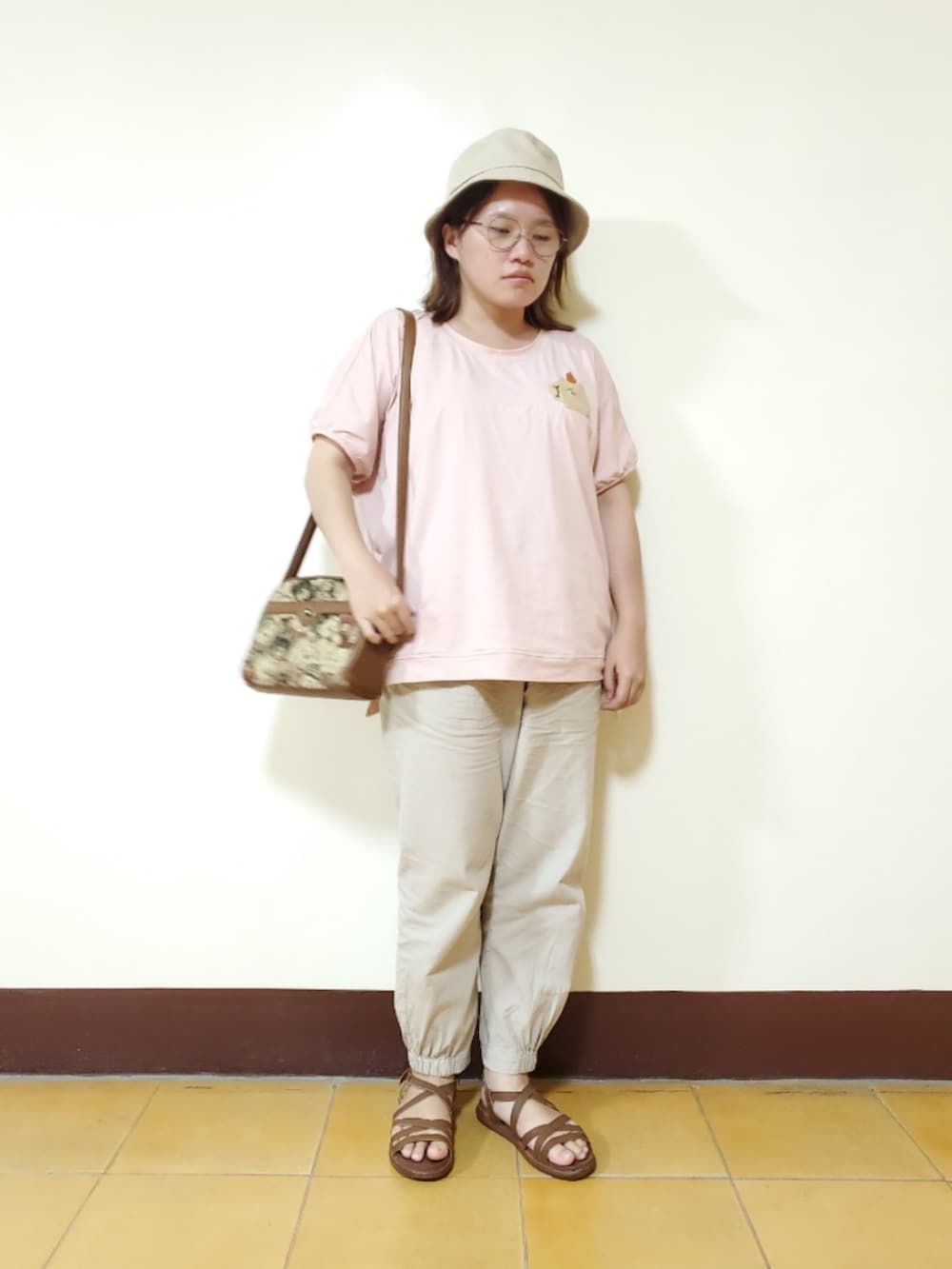 ピンク系のTシャツ/カットソー、ベージュ系のその他パンツ、イエロー系のサンダルを着用したレディースの秋コーディネートの2枚目の写真