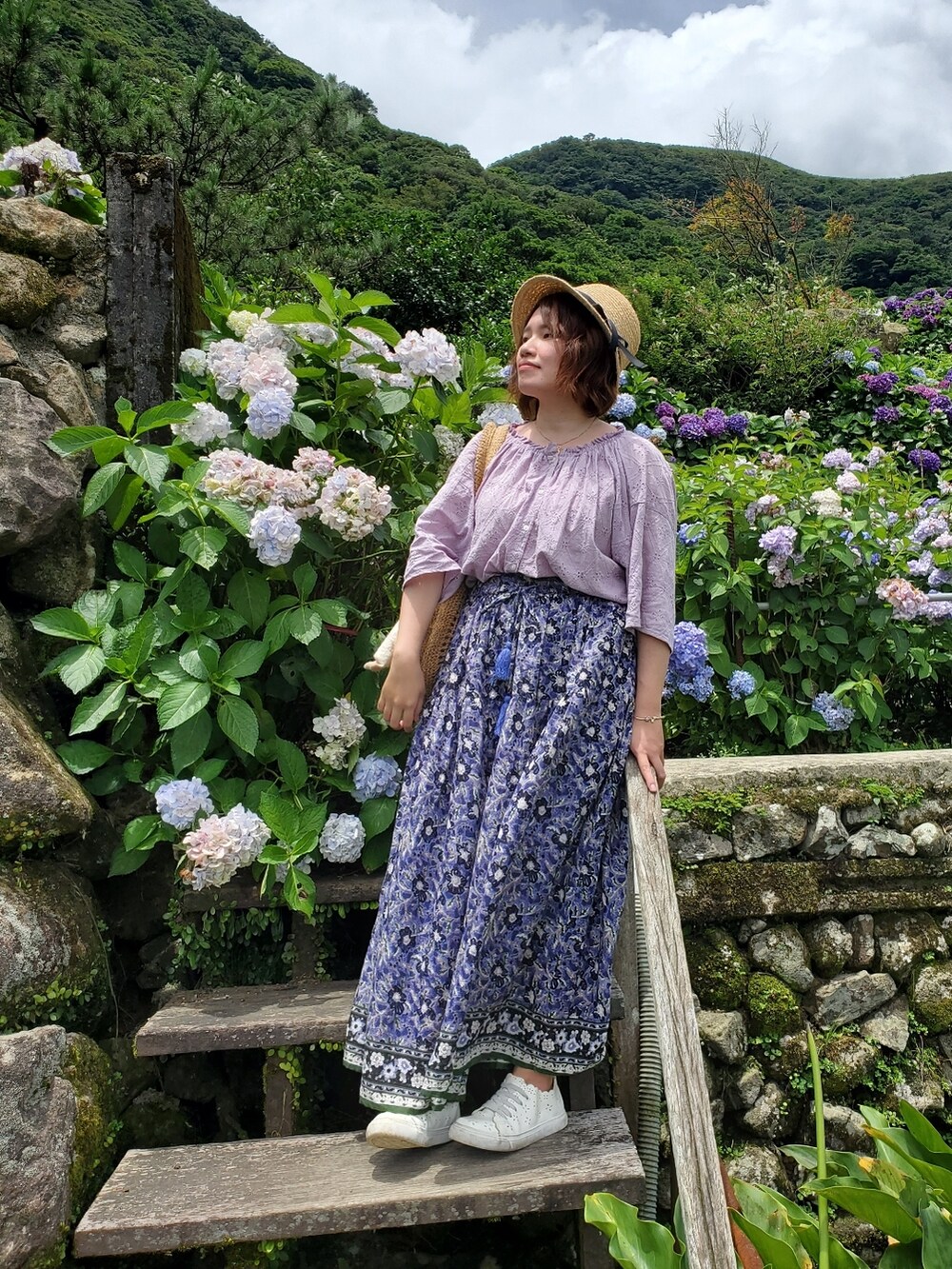 パープル系のシャツ/ブラウス、ブルー系のスカート、ホワイト系のスニーカーを着用したレディースの夏コーディネートの5枚目の写真