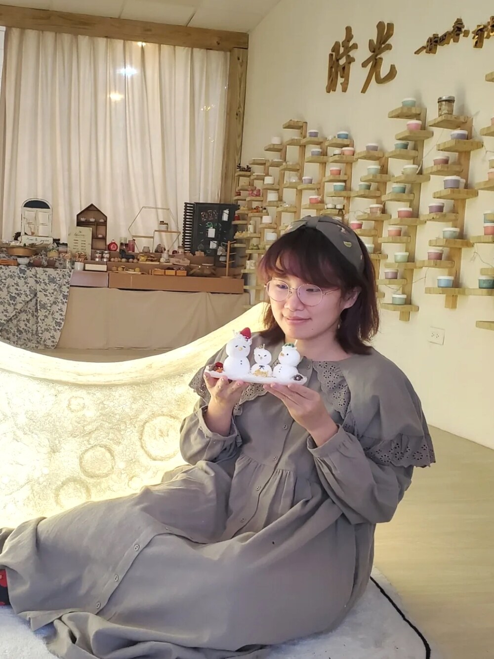 グリーン系のワンピース、ベージュ系のニット/セーター、ブラウン系のブーツを着用したレディースの冬コーディネートの3枚目の写真