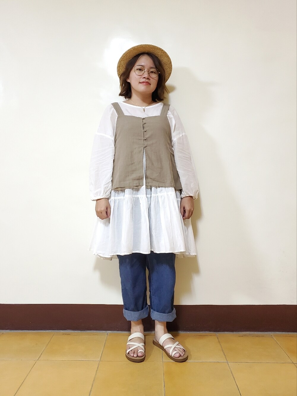 ブラウン系のベスト、ホワイト系のシャツ/ブラウス、ブルー系のデニムパンツを着用したレディースの夏コーディネートの2枚目の写真