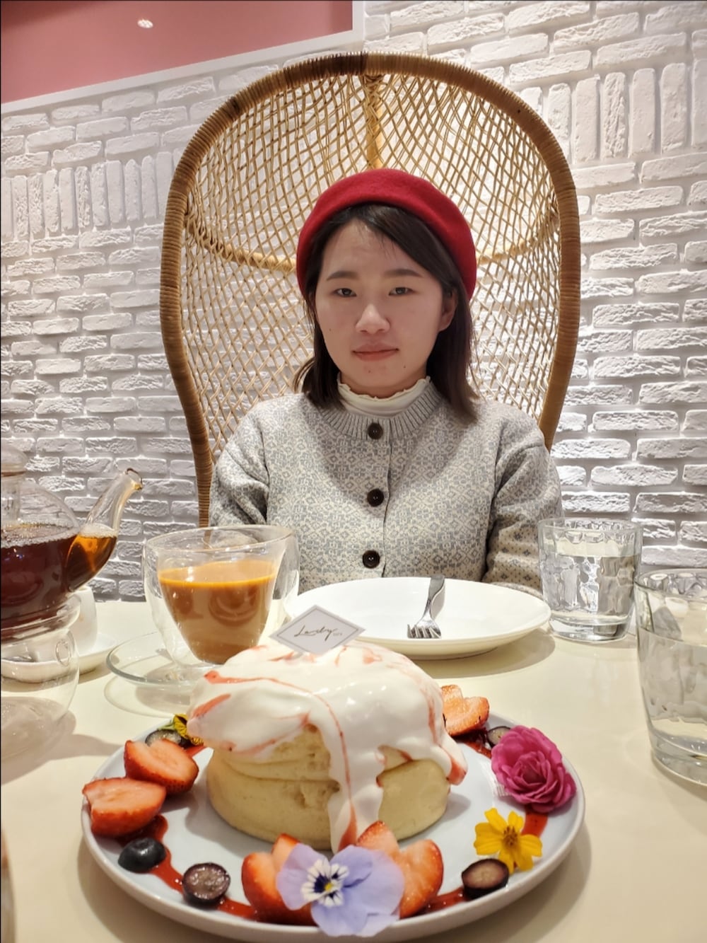 グレー系のダッフルコート、グリーン系のカーディガン/ボレロ、ホワイト系のTシャツ/カットソーを着用したレディースの冬コーディネートの3枚目の写真