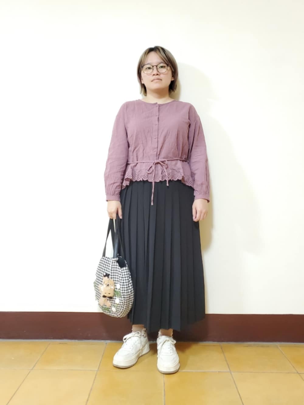 パープル系のワンピース、ブラック系のスカート、ホワイト系のスニーカーを着用したレディースの夏コーディネートの2枚目の写真