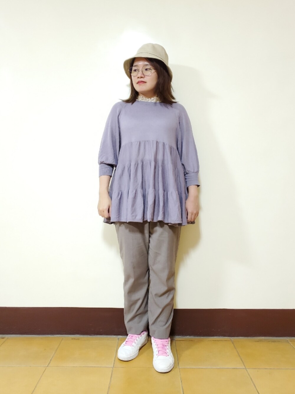 パープル系のニット/セーター、ホワイト系のTシャツ/カットソー、グレー系のスラックスを着用したレディースの秋コーディネートの3枚目の写真