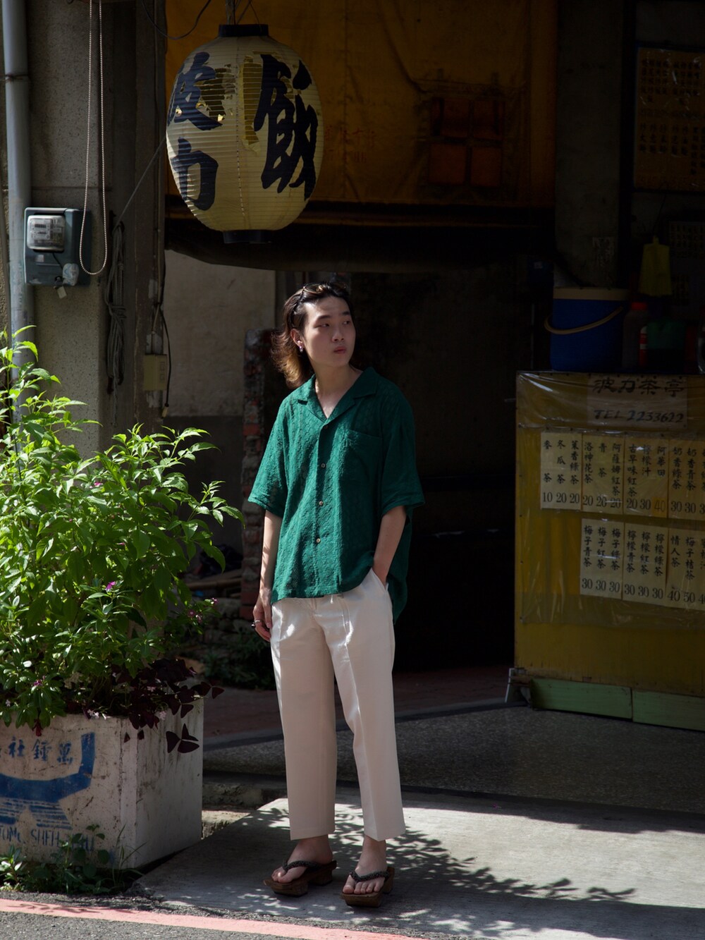 グリーン系のアンサンブル、ホワイト系のスラックス、グリーン系のメガネを着用したメンズの夏コーディネートの2枚目の写真