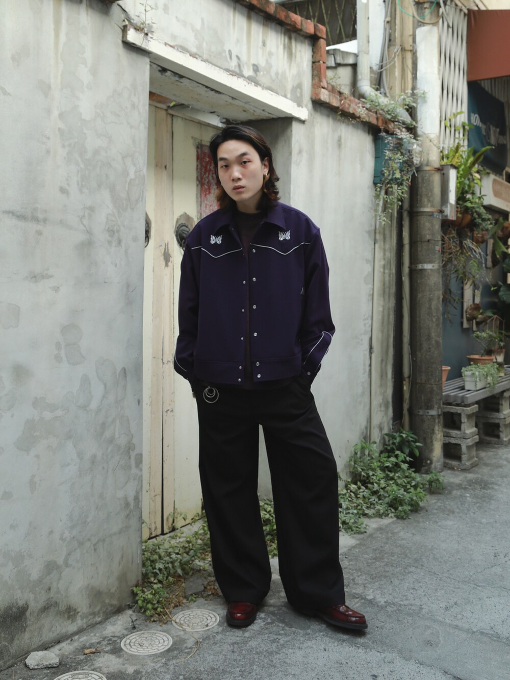 パープル系のニット/セーター、パープル系のデニムジャケット、ブラック系のチノパンツを着用したメンズの秋コーディネートの2枚目の写真