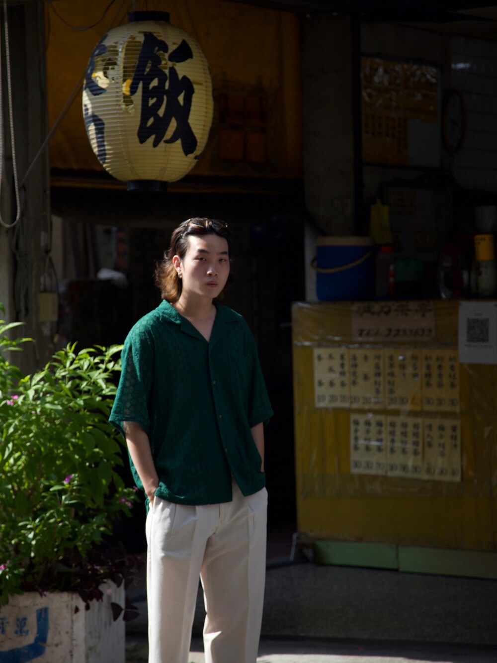 グリーン系のアンサンブル、ホワイト系のスラックス、グリーン系のメガネを着用したメンズの夏コーディネートの3枚目の写真