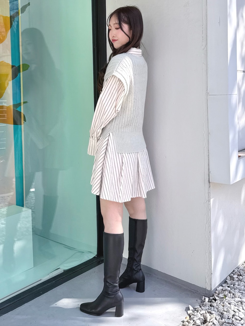 ブラック系のブーツ、グリーン系のワンピースを着用したレディースの冬コーディネートの2枚目の写真