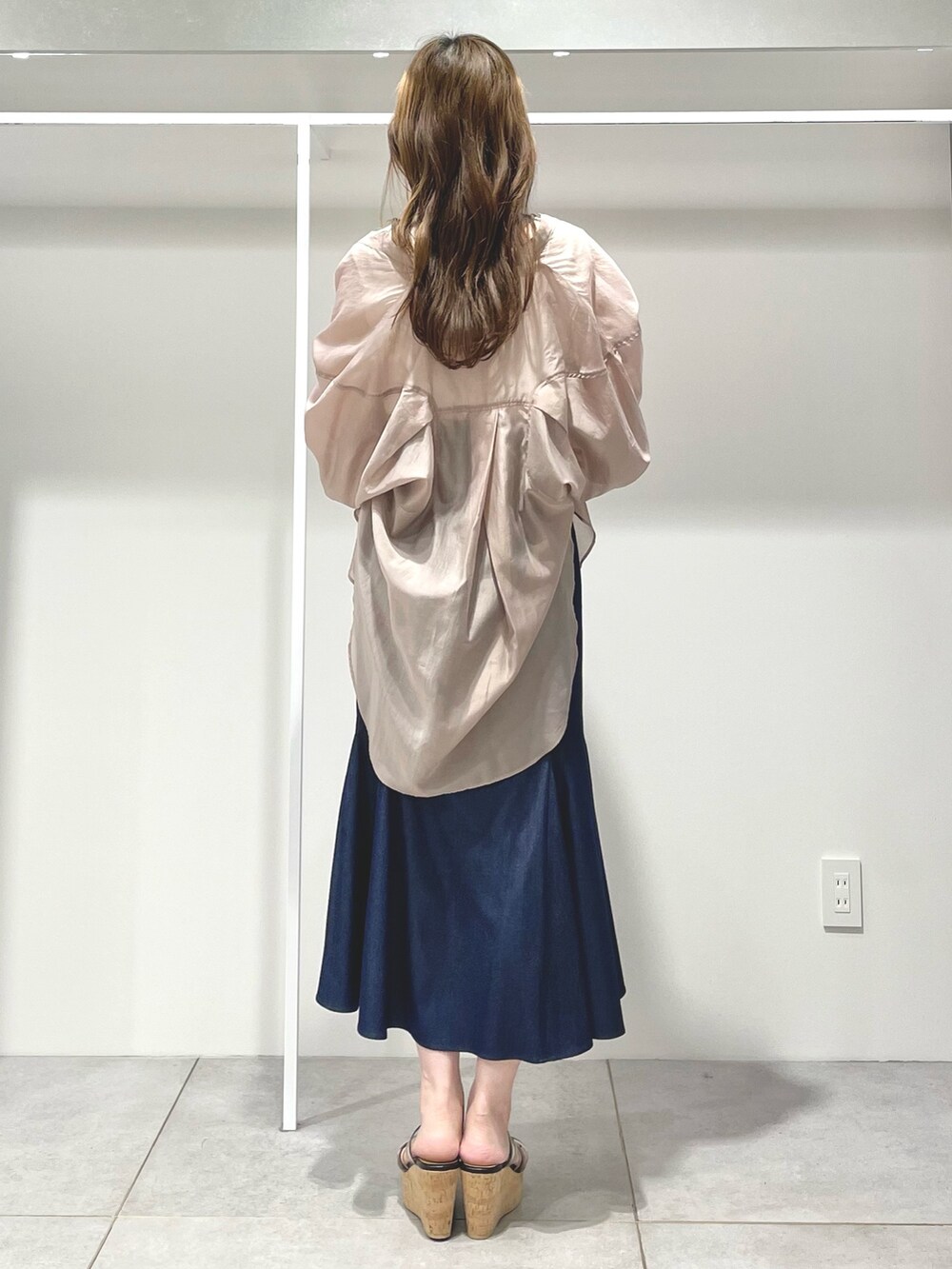 ブルー系のスカート、ブラック系のサンダル、ベージュ系のシャツ/ブラウスを着用したレディースの春コーディネートの3枚目の写真