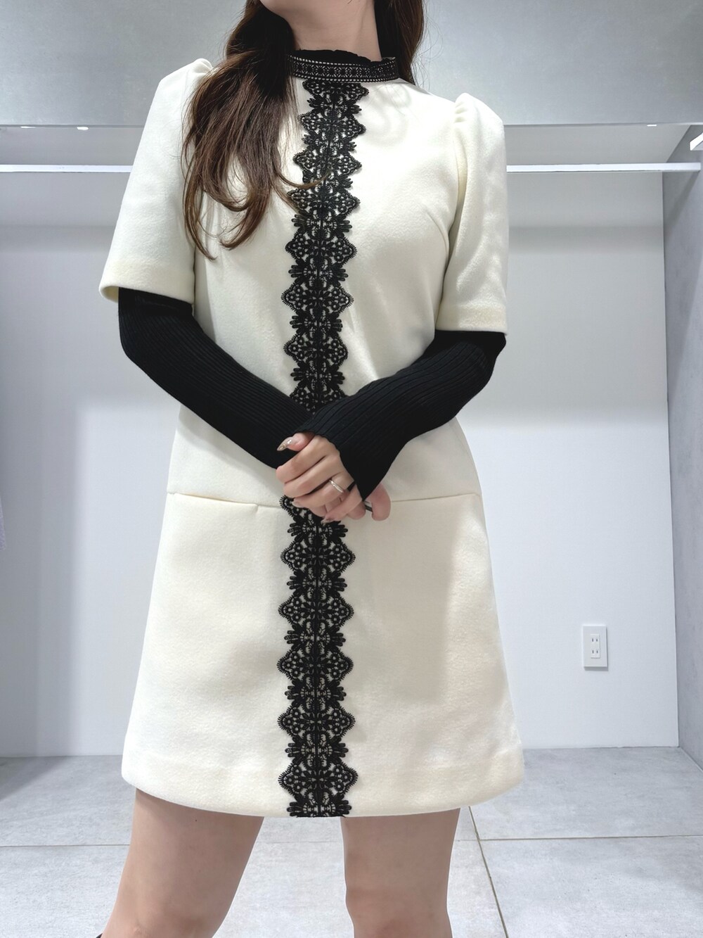 ホワイト系のワンピース、ブラック系のニット/セーター、ブラウン系のハンドバッグを着用したレディースの秋コーディネートの5枚目の写真