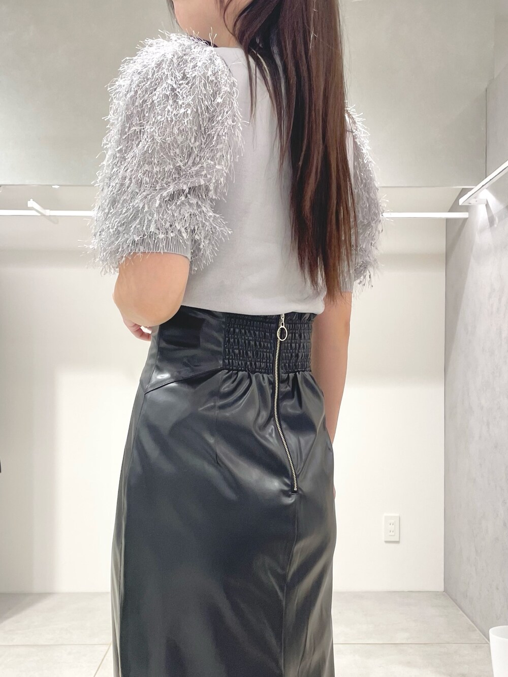 グレー系のニット/セーター、ブラック系のスカート、ブラック系のショルダーバッグを着用したレディースの秋コーディネートの6枚目の写真