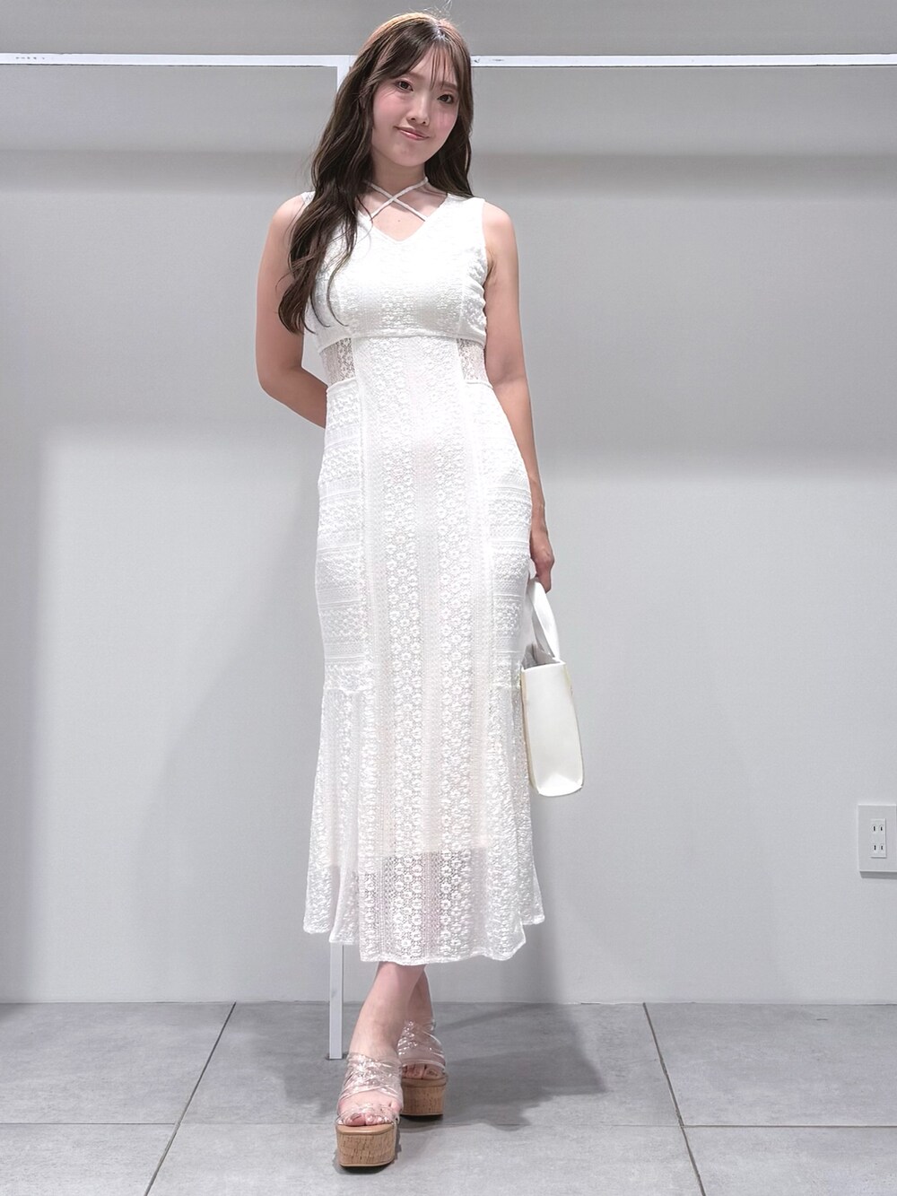 ホワイト系のトートバッグ、ホワイト系のワンピース、その他のサンダルを着用したレディースの夏コーディネートの2枚目の写真