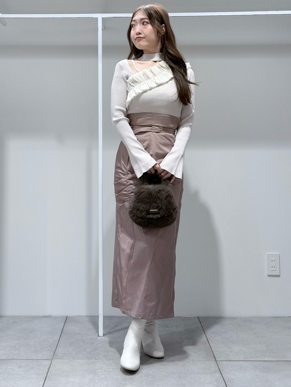 ホワイト系のニット/セーター、ブラウン系のハンドバッグ、ピンク系のスカートを着用したレディースの秋コーディネートの2枚目の写真