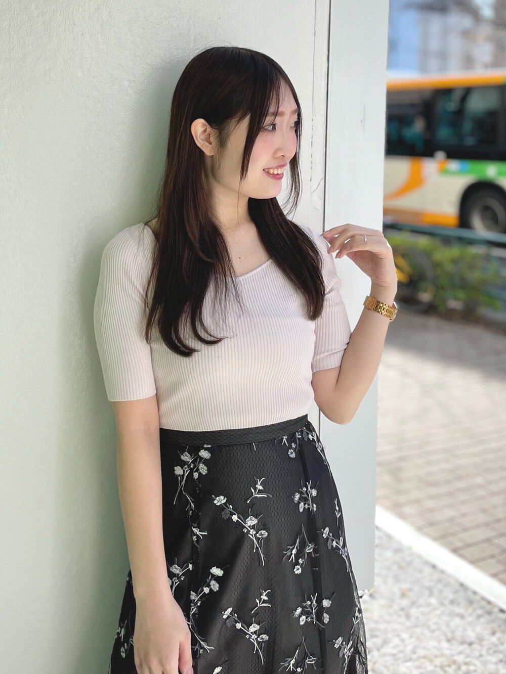 ピンク系のニット/セーター、グレー系のスカート、ホワイト系のサンダルを着用したレディースの春コーディネートの3枚目の写真