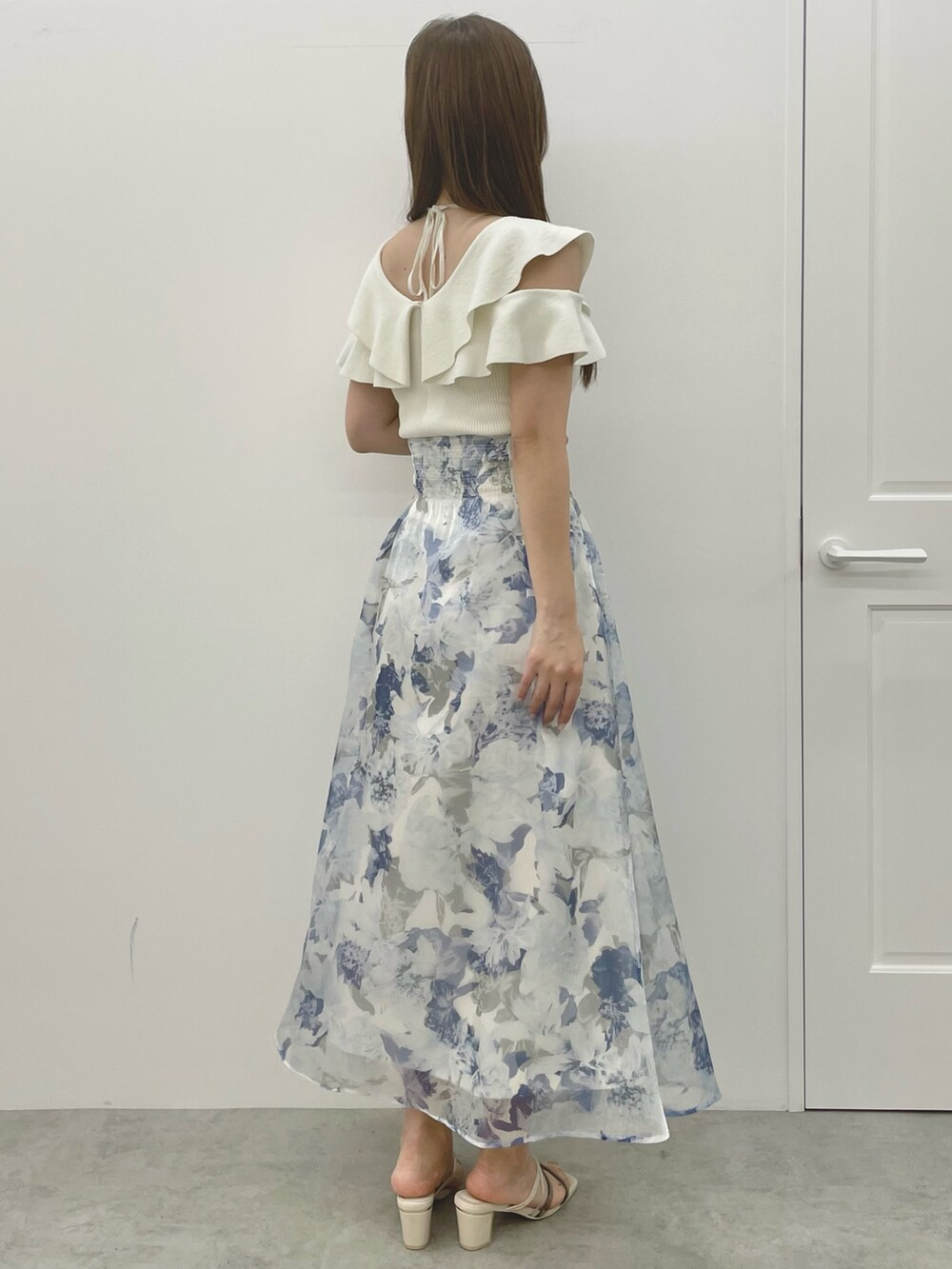 ホワイト系のニット/セーター、ブルー系のスカート、ホワイト系のサンダルを着用したレディースの夏コーディネートの4枚目の写真