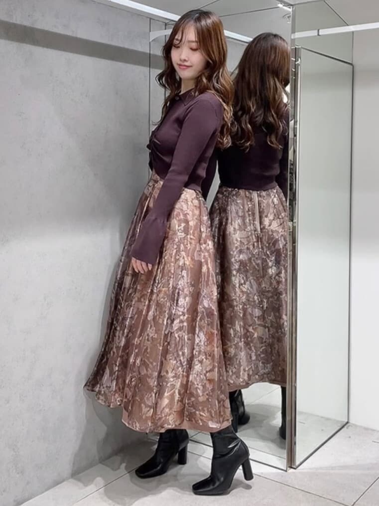 ブラウン系のカーディガン/ボレロ、ブラック系のブーツ、ブラウン系のスカートを着用したレディースの秋コーディネートの3枚目の写真