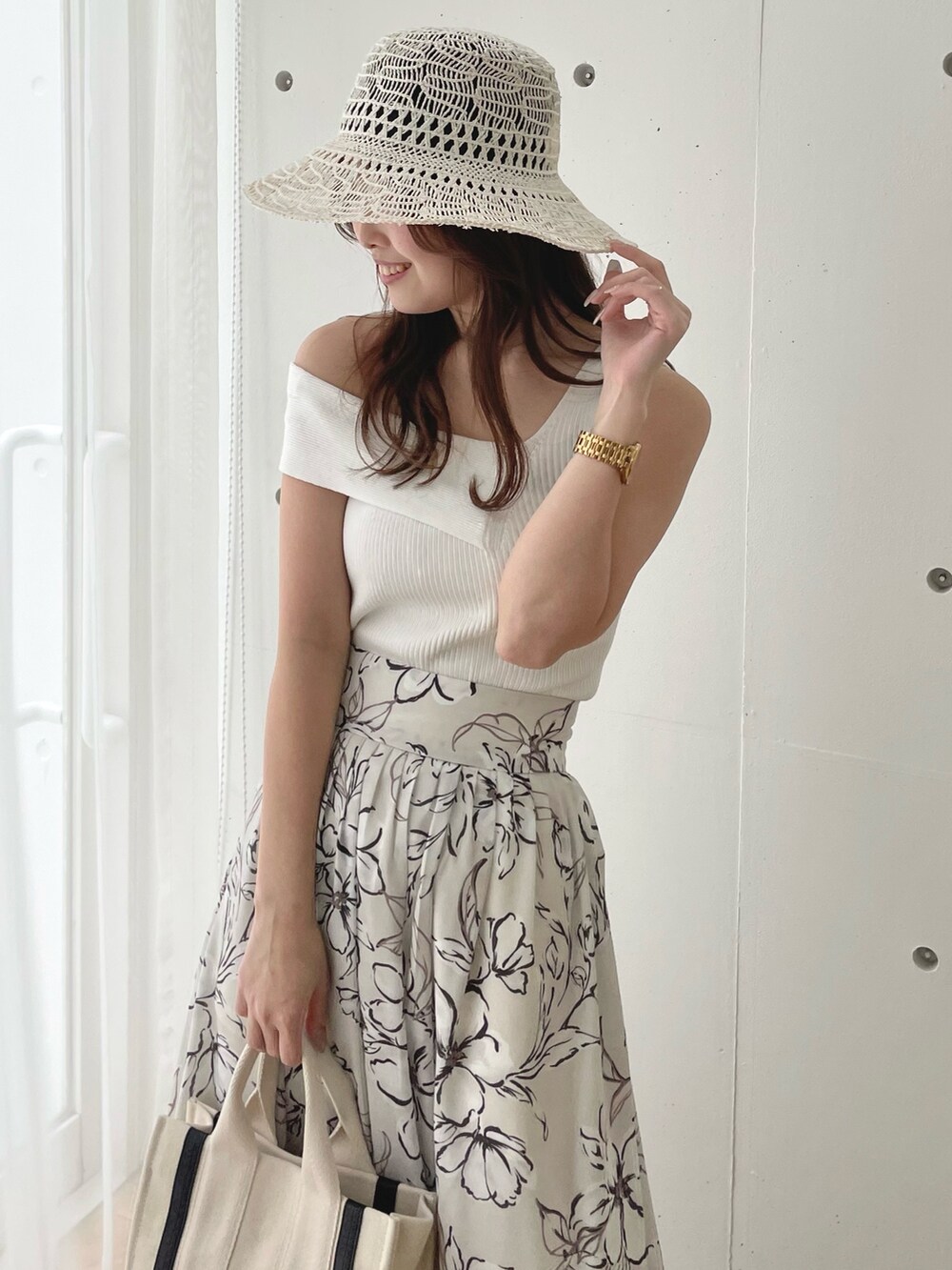 ホワイト系のニット/セーター、ホワイト系のスカート、ホワイト系のサンダルを着用したレディースの春コーディネートの5枚目の写真