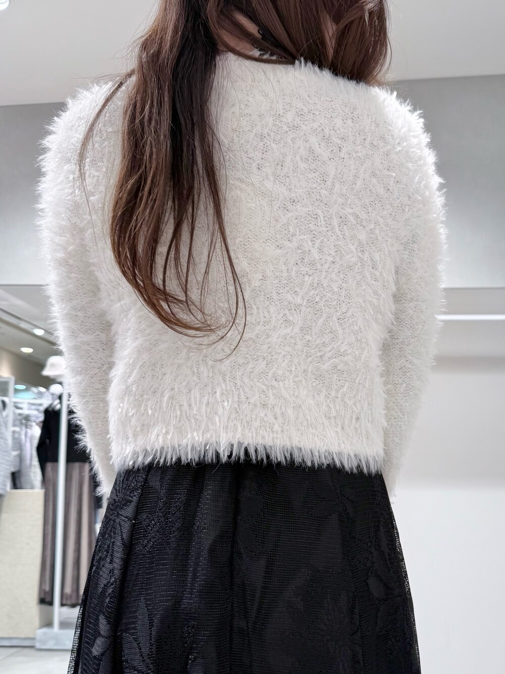 ブラック系のワンピース、ホワイト系のカーディガン/ボレロ、ホワイト系のハンドバッグを着用したレディースの冬コーディネートの8枚目の写真