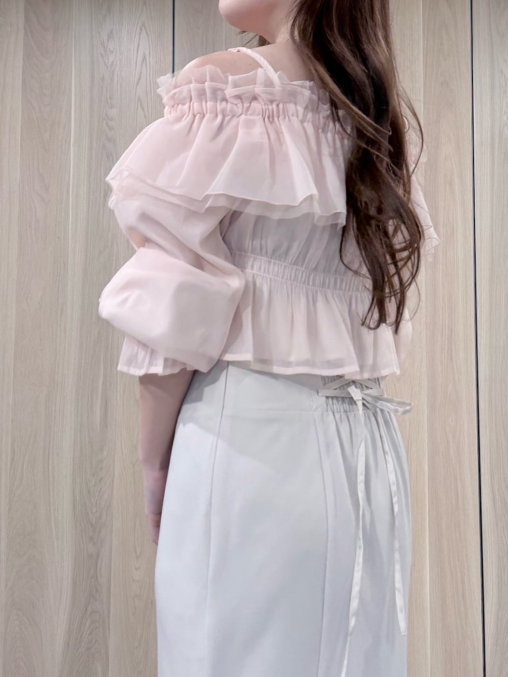 ピンク系のシャツ/ブラウス、ホワイト系のスカート、ホワイト系のパンプスを着用したレディースの春コーディネートの6枚目の写真