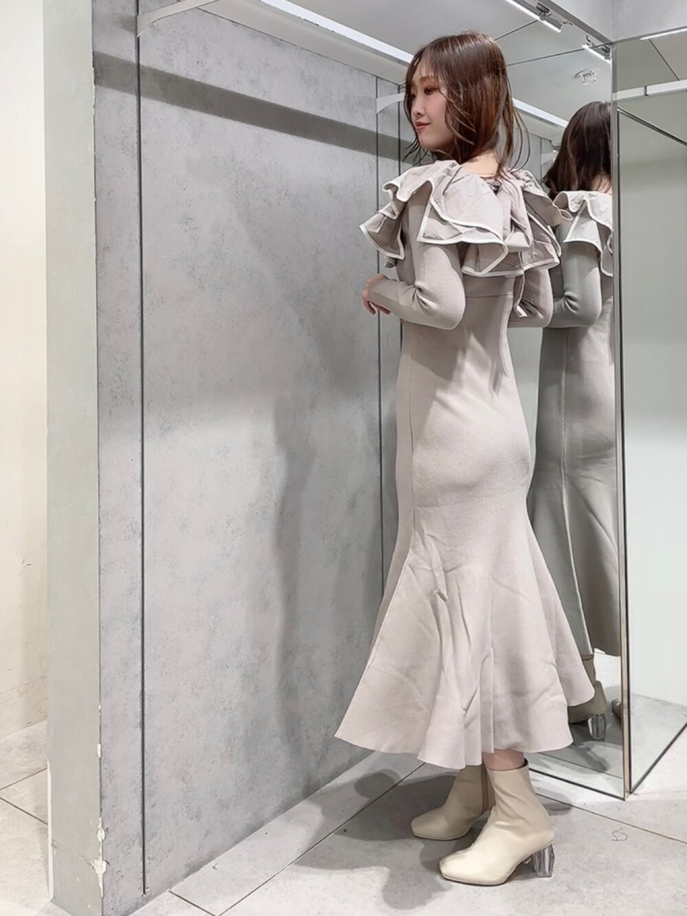 ベージュ系のワンピース、ホワイト系のブーツを着用したレディースの秋コーディネートの3枚目の写真