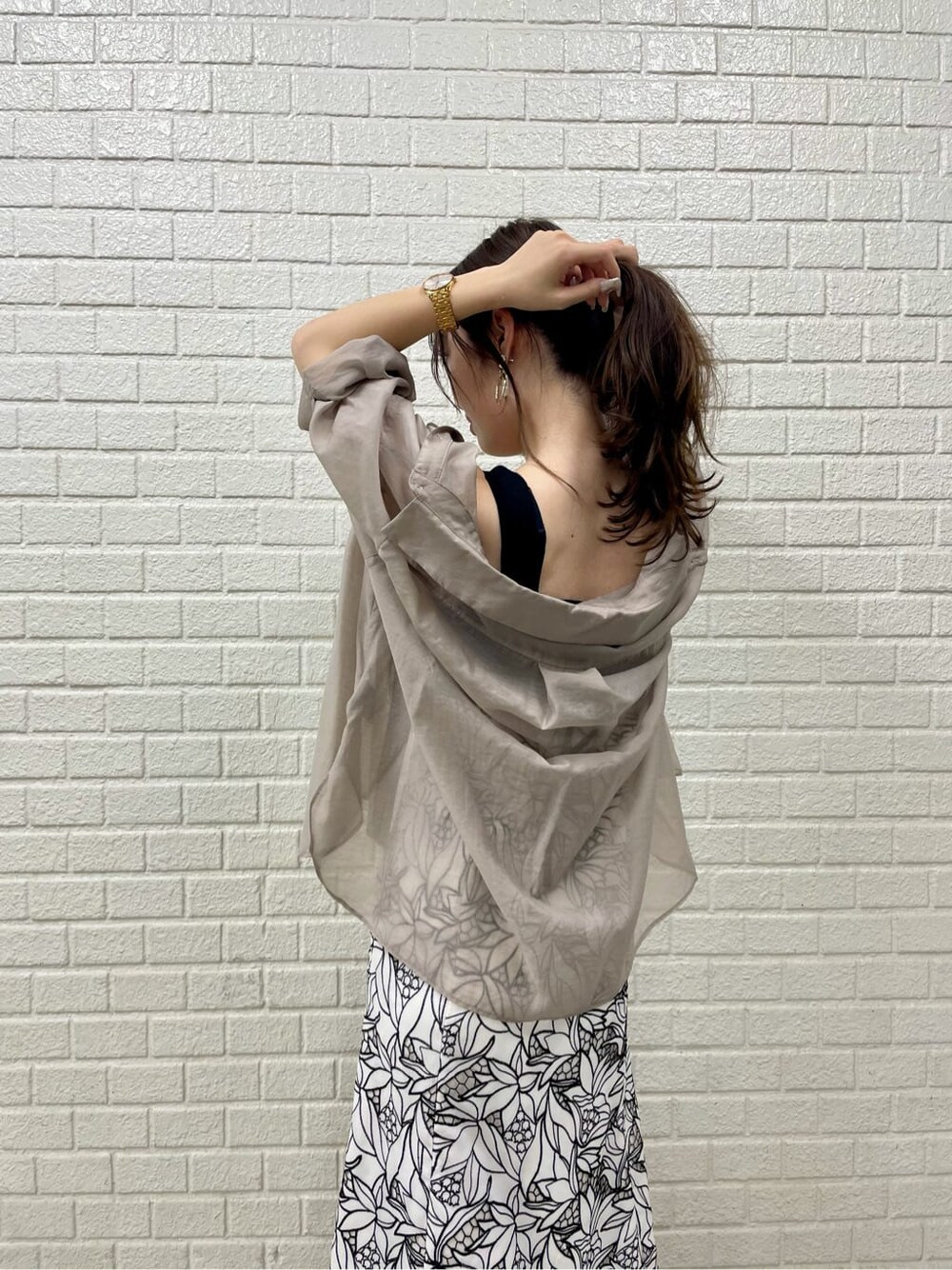 ベージュ系のサンダル、ブラック系のワンピース、ベージュ系のシャツ/ブラウスを着用したレディースの夏コーディネートの3枚目の写真