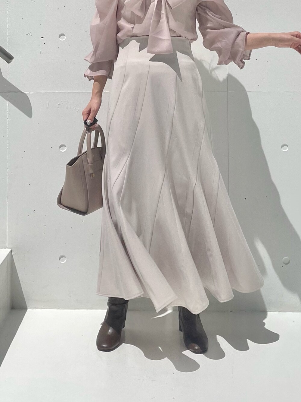 グレー系のテーラードジャケット、ベージュ系のシャツ/ブラウス、ベージュ系のスカートを着用したレディースの秋コーディネートの10枚目の写真